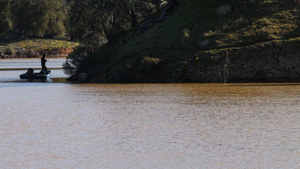 A fisherman works around a point at a full Santa Margarita Lake. It was standing at 101% capacity on Feb. 15, 2023 with docks at maximum lake level and all boat launch ramps open and fishing enthusiasts hoping the water will clear.