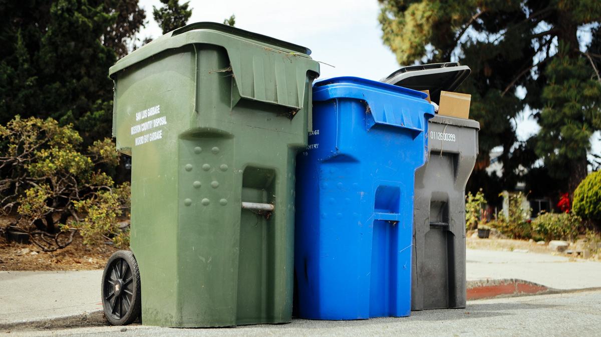 Recycling, center, trash, right and green waste bins sit on the side of Margarita Avenue in San Luis Obispo.