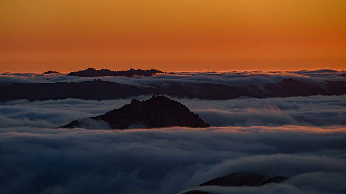 Low marine clouds roll into the coastal valleys of the Central Coast.