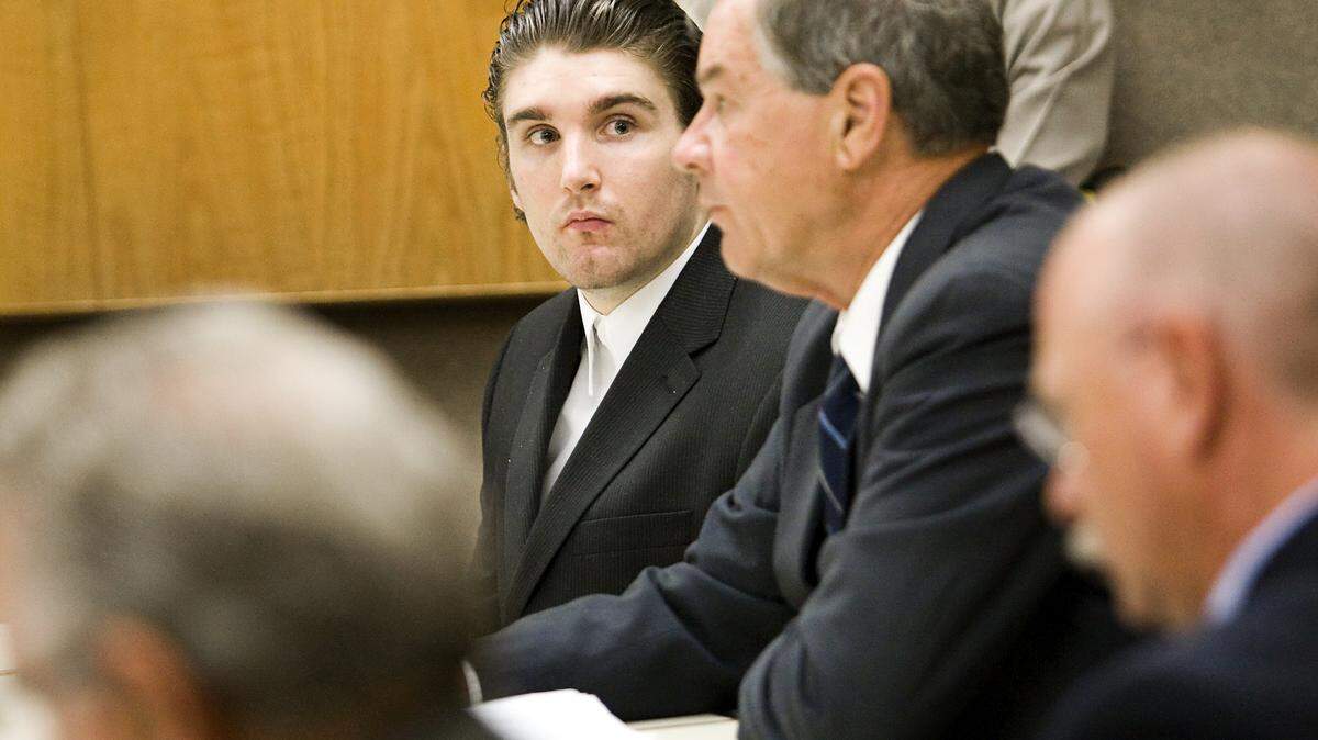 Brandon Henslee, left, looks at his attorney, Fred Foss, during his trial for murder Thursday, Sept. 12.