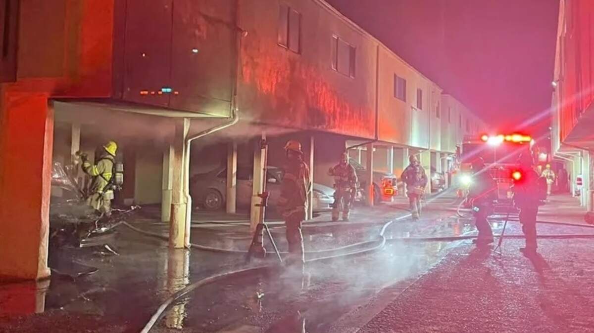 Firefighters battle a blaze in parking stalls underneath the Twin Palm Apartment on the 300 block of East Bunny Avenue early Sunday morning, Feb. 22, 2026.