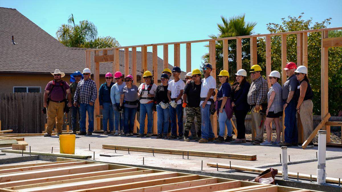 People’s Self-Help Housing staff and future residents of Summer Holly Lane Homes pose for a picture in front of the first wall raised in the project. The 10-unit housing project in Nipomo will be built by its future residents, and is the first housing project in San Luis Obispo County to build residential homes on a commercially-zoned lot under the Workforce Housing Ordinance.