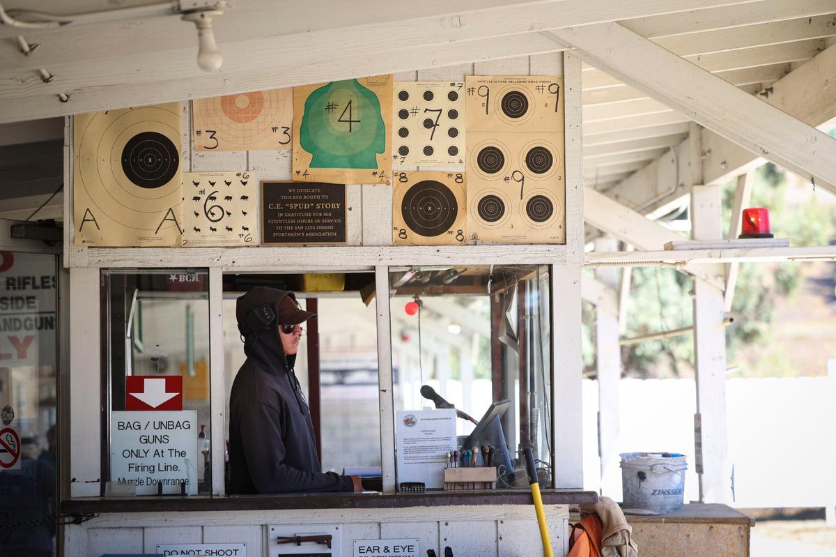 Range safety officer Riley Penir makes sure shooters can safely change targets during a break in the shooting sessions at the San Luis Obispo Sportsmen’s Association shooting range on Sept. 9, 2024. Various target styles for sale are posted on the wall.