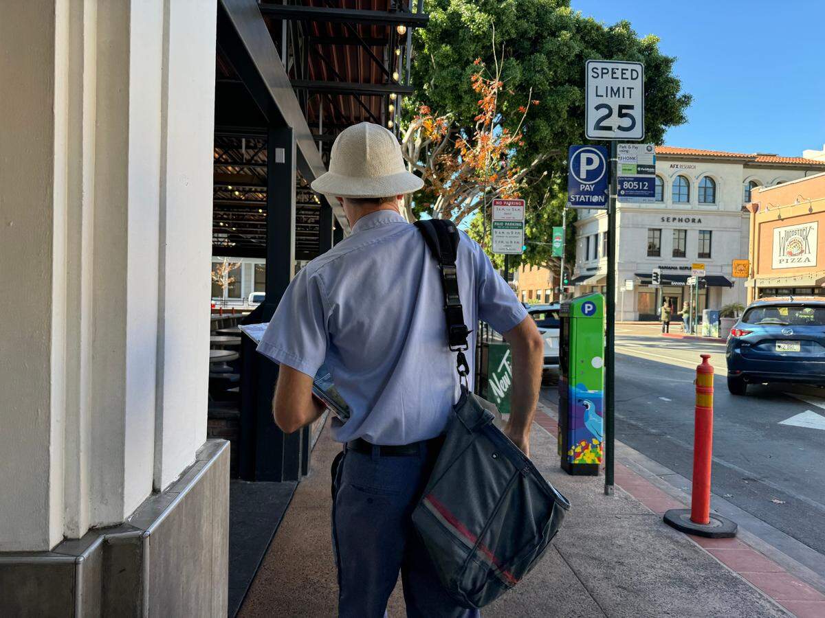 U.S. Postal Service Letter Carrier Zach Sherer delivers mail on Higuera Street in downtown San Luis Obispo on Dec. 4, 2024.