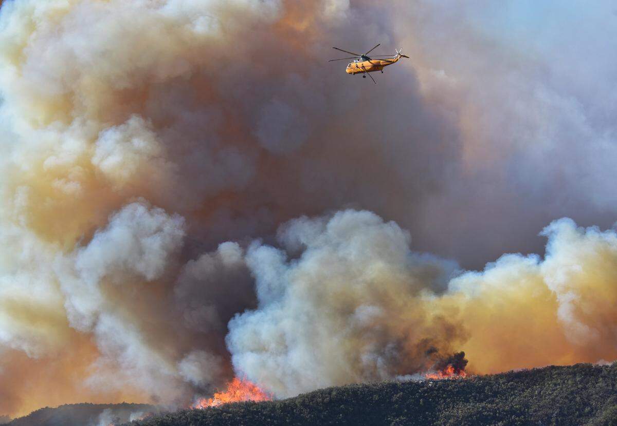 A Croman Corp. Sikorsky SH-3 helicopter heads back to refill its tankand head back to make another water drop on the Alisal Fire burning in Santa Barbara County.