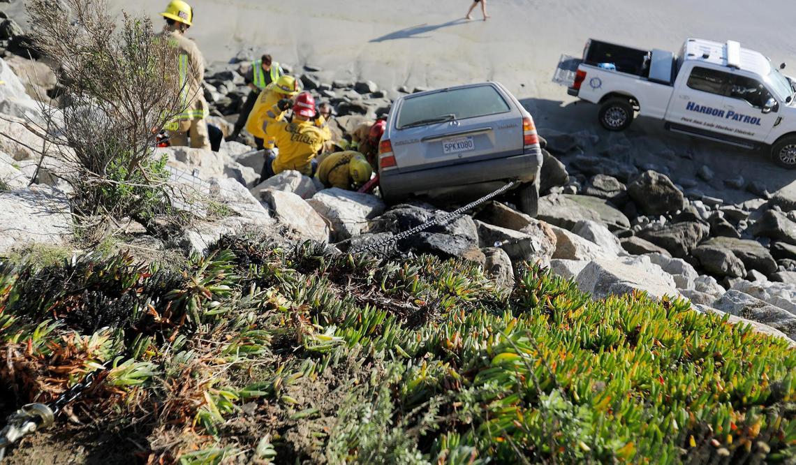 A Cal Fire extracation team helped to free a passenger in the Mercedes hatchback that went over the side of the Avila Beach Drive onto the rocks at Olde Port Beach on Jan. 1, 2025.