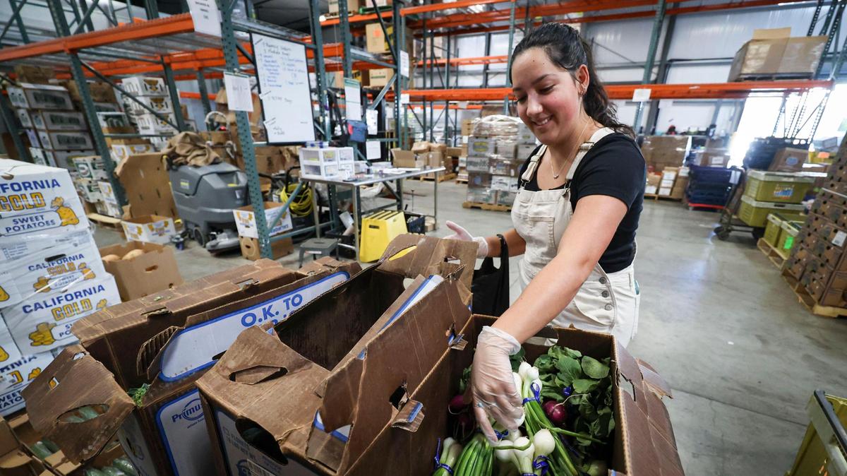 Natalie DeRose picks out vegatables at SLO Food Bank where volunteers and staff put together bags of produce on Dec. 5, 2023.