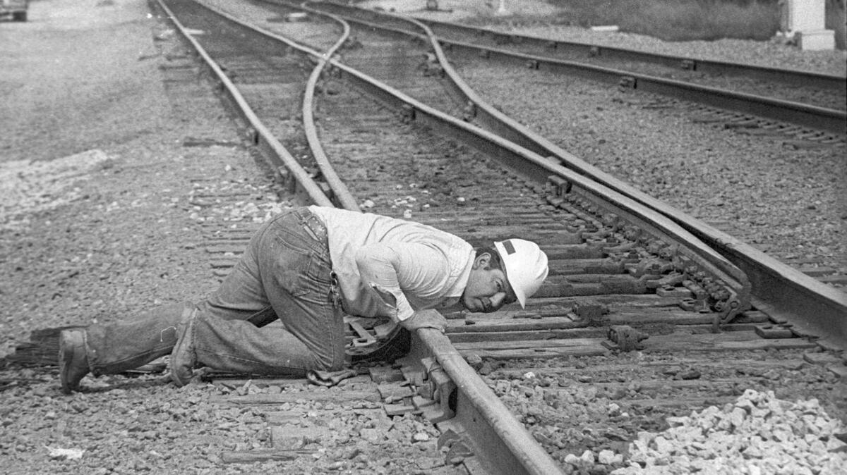 Southern Pacific railroad work crew foreman Tom Lupio sites along railroad track to check repair work March 12, 1984.