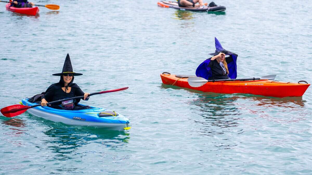 A pair of withces cruise through Morro Bay during the Witches Paddle on Saturday, Oct. 25, 2025. The 13th annual paddle attracted hundreds of witches and creatures of the night taking to the watter on paddleboards, kayaks and other small craft.