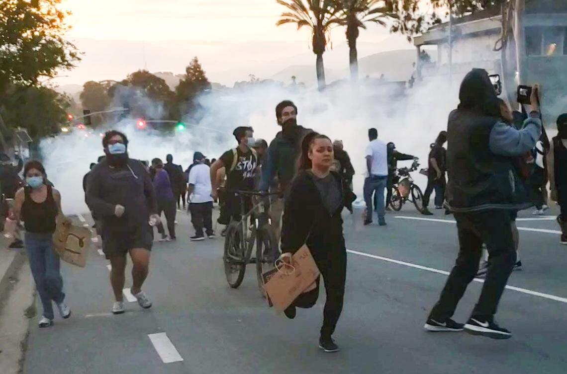 Protesters run south on Santa Rosa Street in San Luis Obispo after police deployed multiple rounds of tear gas and firecrackers to disperse the crowd on June 1, 2020.