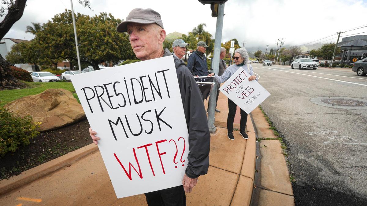 Dan Conroy, who served six years in the National Guard, sees federal cuts to the Veterans Administration as betrayal of promises made to service members. Over 50 protesters gathered near the Veterans Memorial Building in San Luis Obispo with signs in support of veterans services and critical of President Trump and Elon Musk on March 14, 2025.