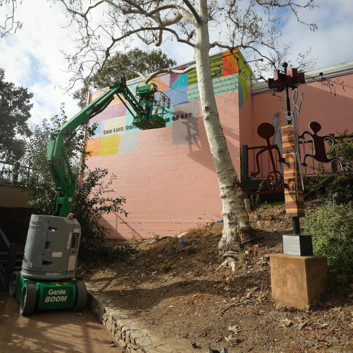 San Francisco artist Leah Rosenberg works on a new mural at the San Luis Obispo Museum of Art on Monday, Feb. 13, 2023. The mural, “SLO(W) RAINBOW,” replaces Erin LeAnn Mitchell’s “Calafia was Here,” and will be on view until February 2024. The rainbow colors are from a color palette generated from the local environment.