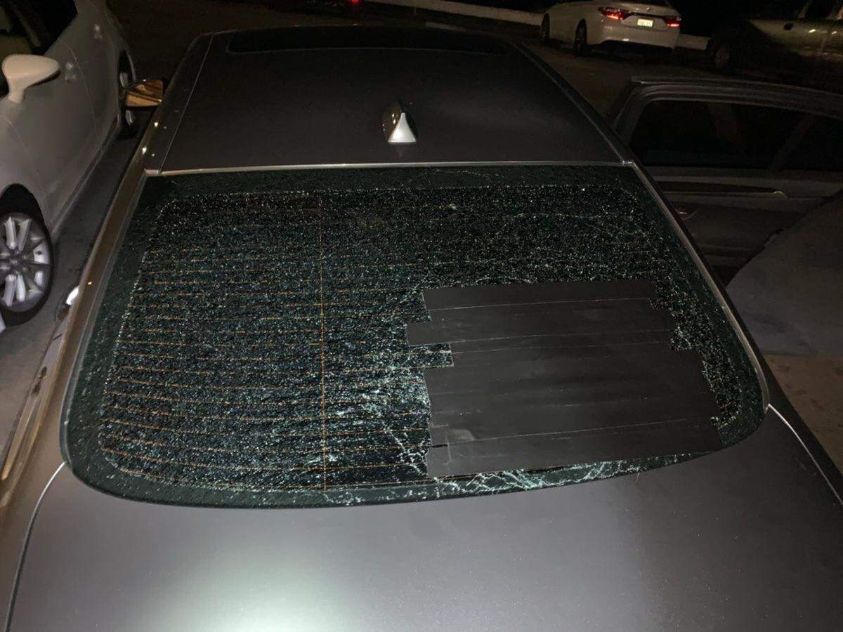 Protesters smashed the window of a gray sedan after it pushed through the crowd while demonstrators were blocking Highway 101 on Tuesday.