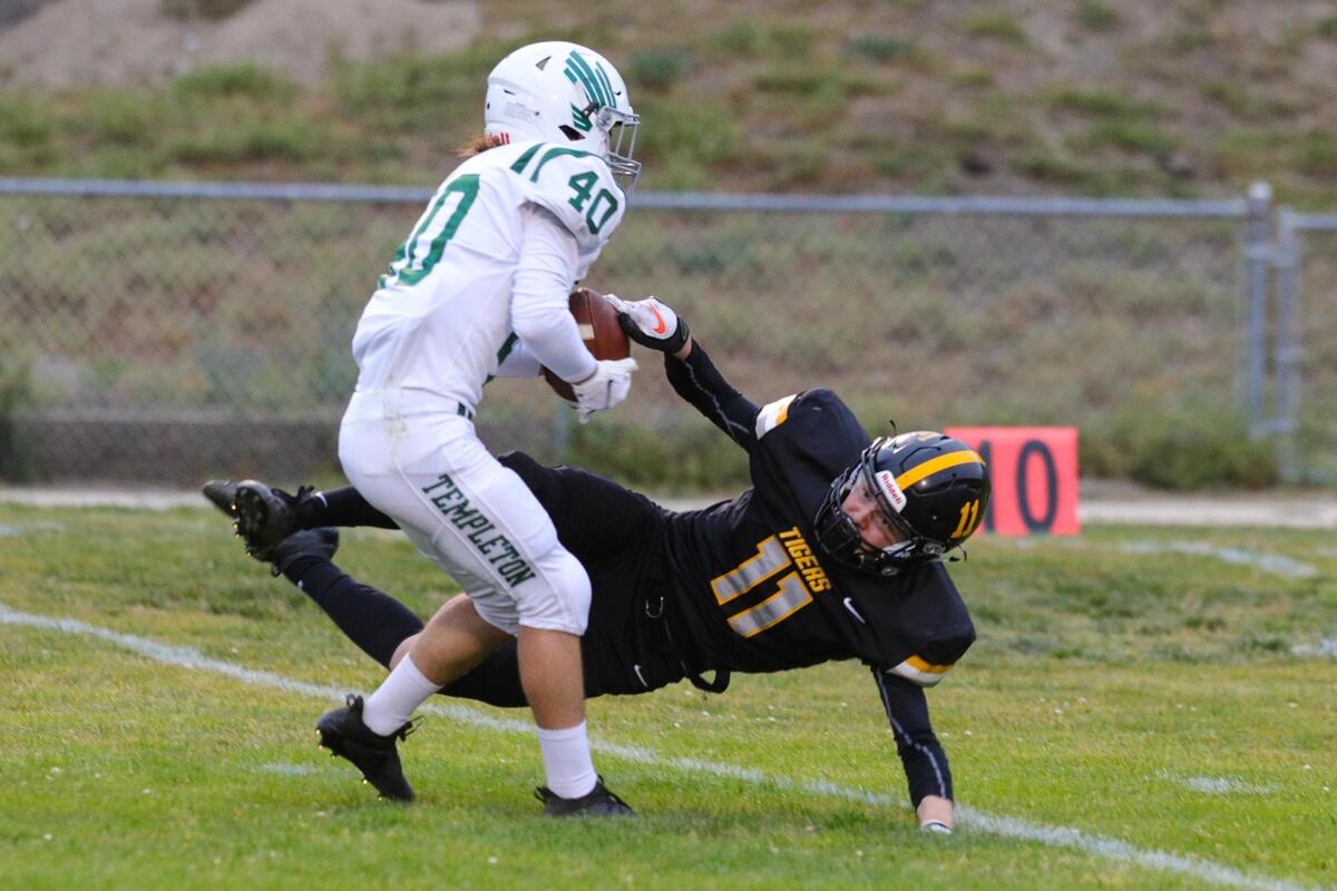 Landen Miller of Templeton comes down with the ball as Riesen Carlberg of San Luis Obispo tries to knock it away. San Luis Obispo hosted Templeton in the next to last football game of the season. Templeton won 20-13.
