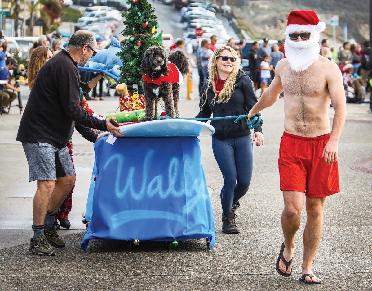 The O’Conner family, with members from Avila Beach, Denver and Indianapolis, pull Wally the family dog through Santa’s Doggie Parade in Avila Beach in 2018. The parade returns to the Avila Beach Promenade on Dec. 10, 2022.