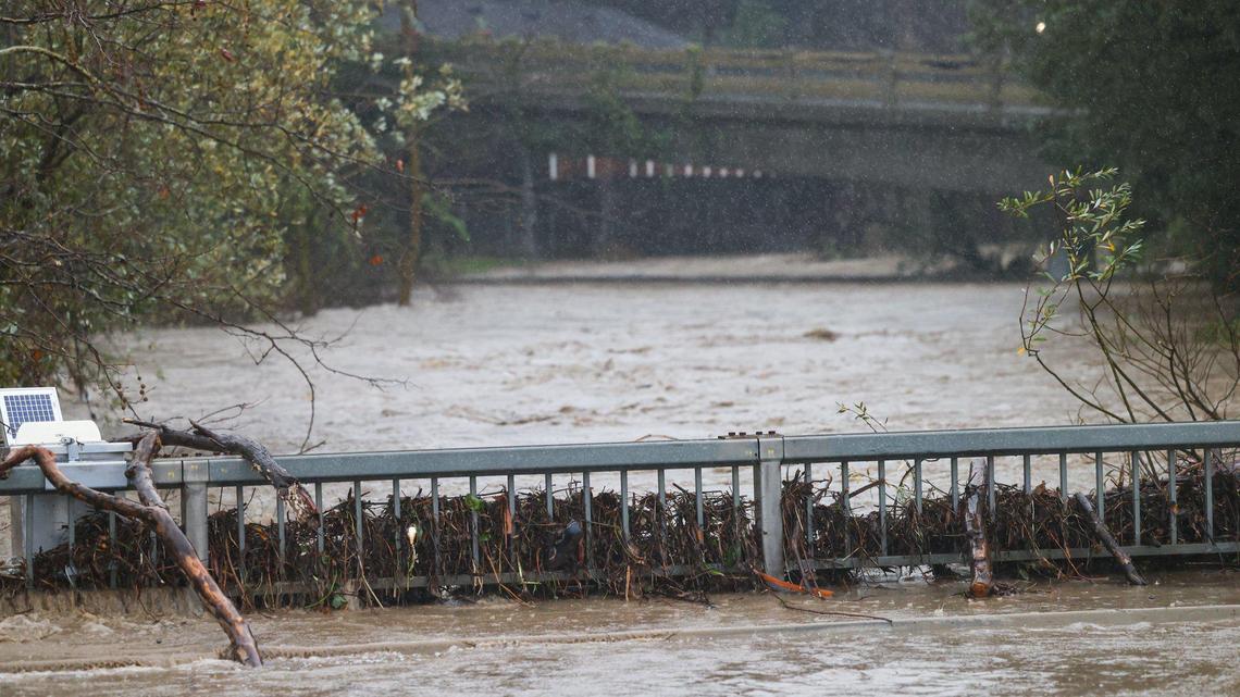 Storm debris piles up on the Marsh Street bridge near on-ramps to Highway 101 as rain falls over San Luis Creek. Flooding in SLO County was widespread Jan. 9, 2023, as another “atmospheric river” storm hit the coast.