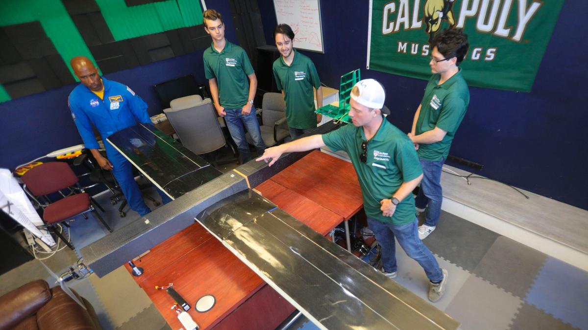 Cal Poly graduate and NASA astronaut Victor Glover visited campus May 29, 2024. He talks to engineering students from left Cole Bushur, Nicholas Toal and Andrew Whitacre. Andrew Sugamele points out details on the electric powered, autonomous flight aircraft they built.
