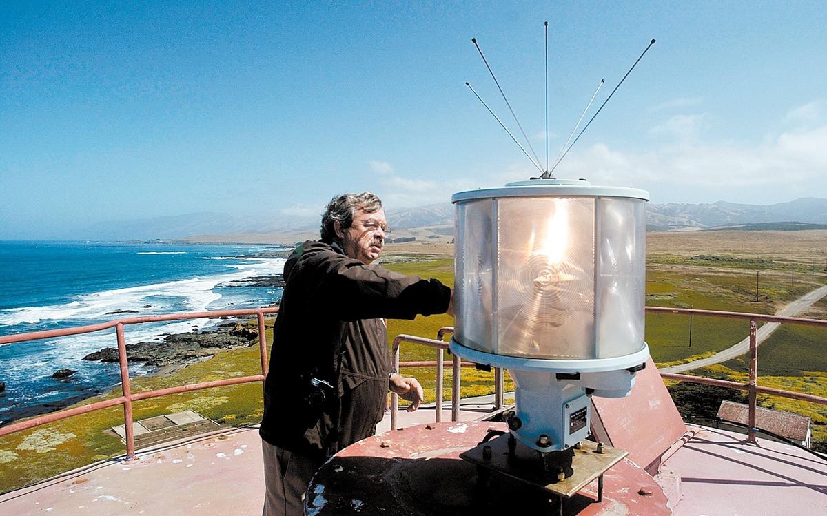 John Bogacki, U.S. Bureau of Land Management site manager for the Piedras Blancas Light Station in 2003, cleans the glass of the light. Public tours will not go to the top of the 74-foot tower until restorations have been made to the stairway.