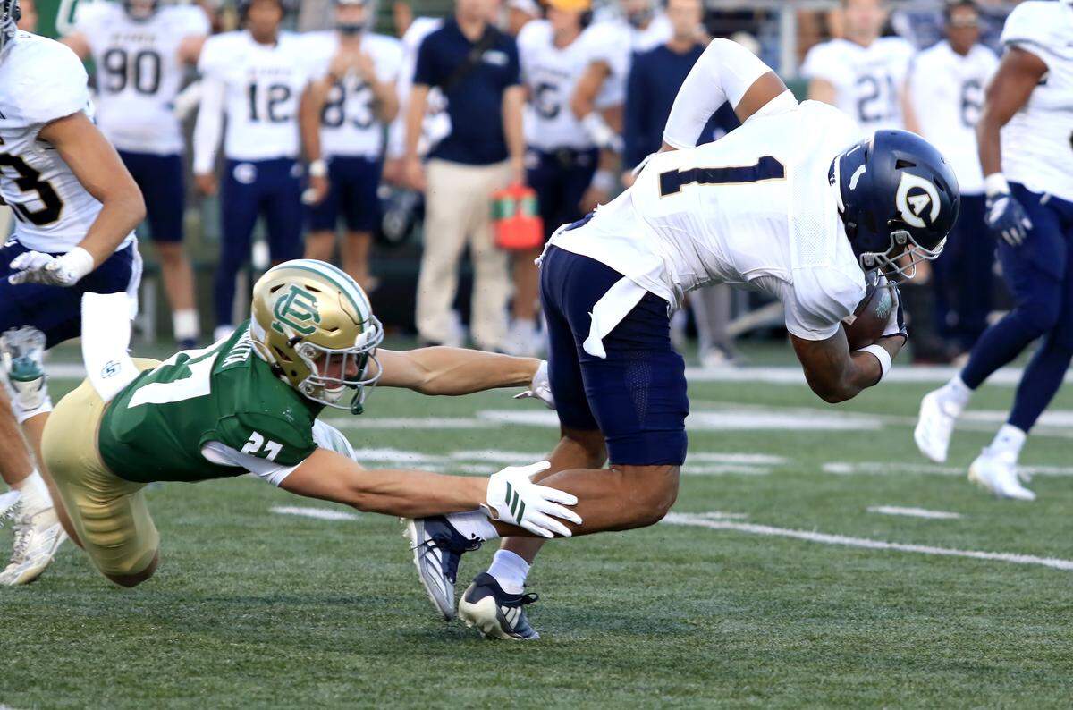 Mustang Hudson Giarritta dives to tackle Aggie Khalani Riddick. Cal Poly lost to UC Davis 34-27 in a college football game at Mustang Memorial Stadium on Oct. 4, 2025.