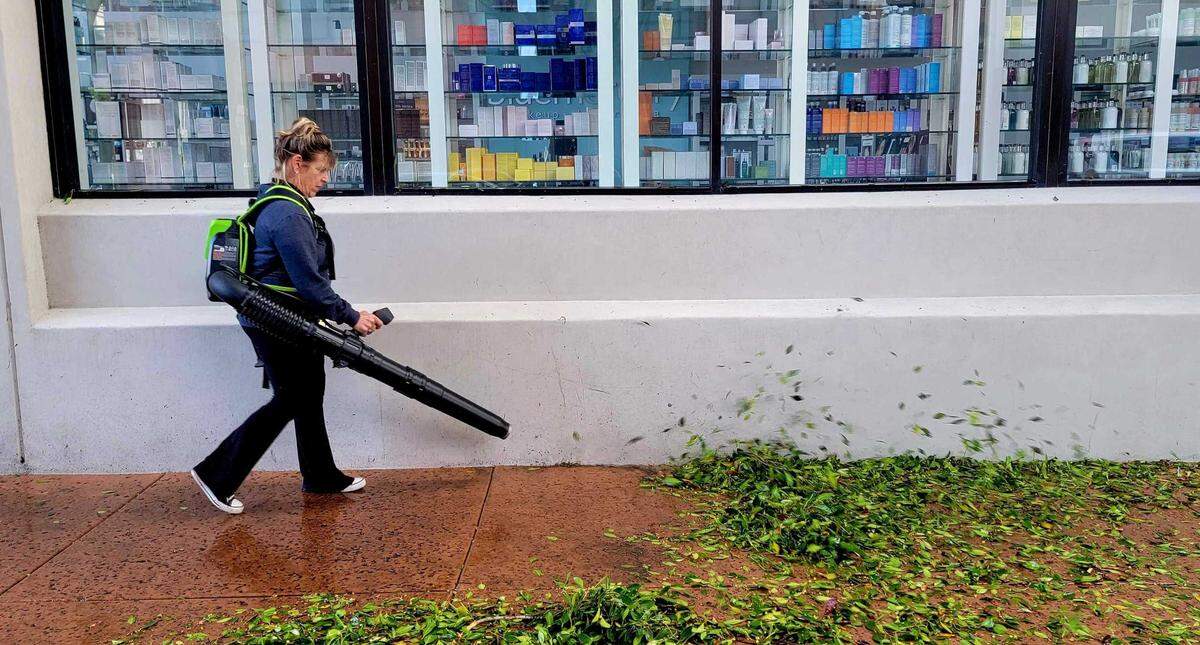Jill Tappan, a maintenance worker for John McGee, cleans storm debris from the sidewalks on Higuera and Morro streets in downtown San Luis Obispo on Sunday, Dec. 11, 2022.
