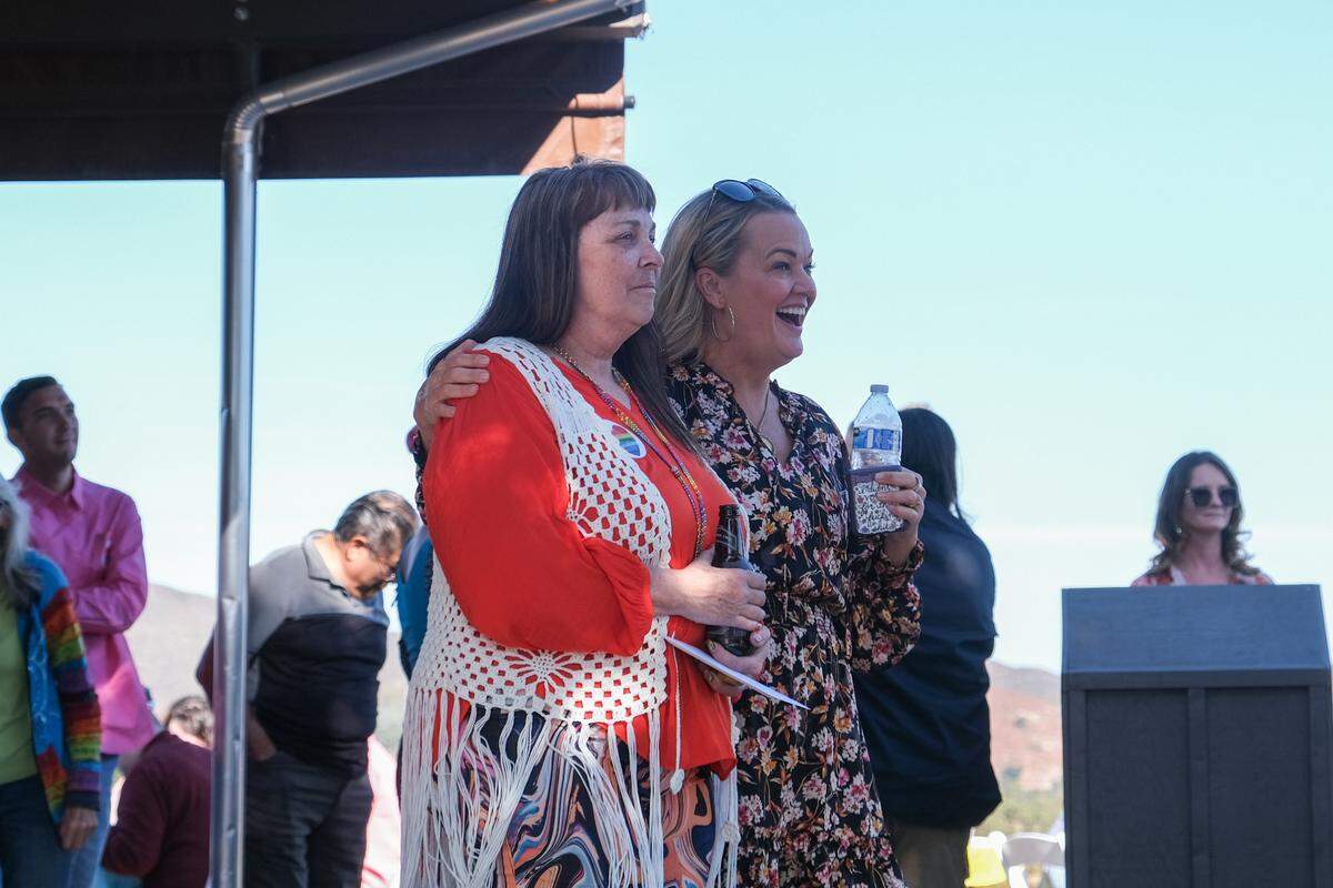 Melody Pinion, left, and a friend listen to people share stories about her son, Todd Pinion, at his memorial in Santa Margarita on Nov. 9, 2024. Pinion was killed in an alleged hate crime on Oct. 23, 2024.
