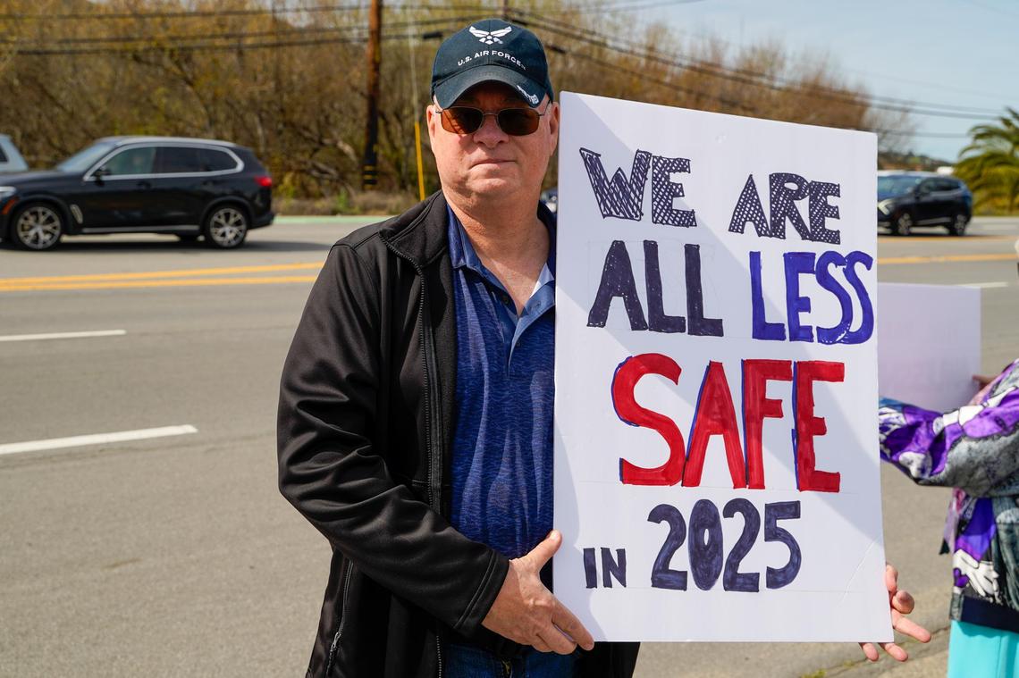 Retired United States Air Force Master Chief Nolan Meeks holds a sign during a protest on Los Osos Valley Road on Monday, Feb. 17, 2025. Meeks said Donald Trump and Elon Musk’s first month in office represent a threat to veterans and programs such as Medicare.