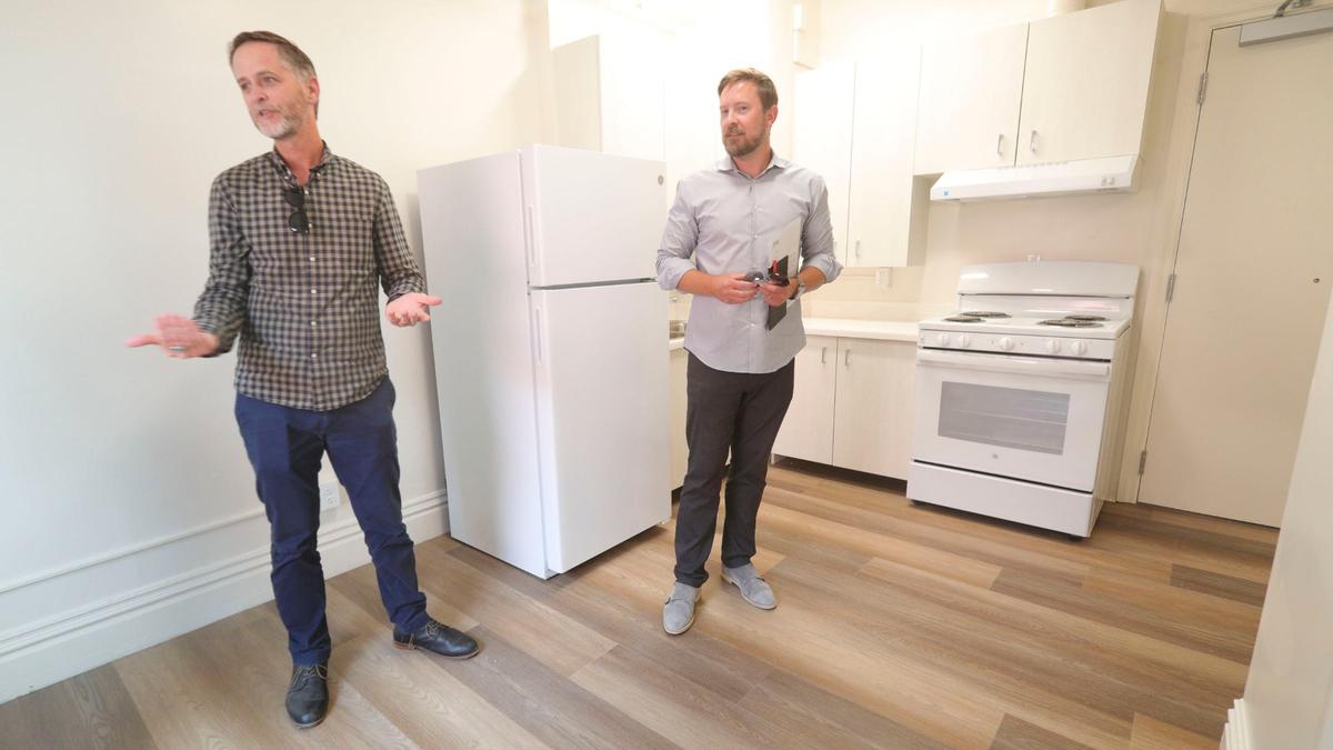Scott Collins, HASLO executive director, left, and Michael Burke, director of construction and development, give a tour of a renovated studio apartment at the Anderson Hotel Apartments in downtown San Luis Obispo on Sept. 16, 2024. The Housing Authority of San Luis Obispo will manage the living spaces, and the ground floor will have business spaces, some with returning clients.