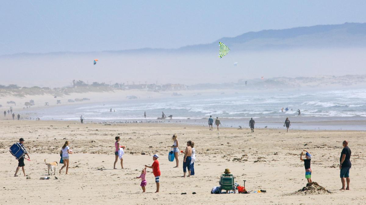 Wind brings out kite fliers and kite board riders surfing the waves at Pismo Beach and a band of dusty air can be seen on April 5, 2022. The air quality index at the CDF station in Nipomo was over 120 at that time, which is unhealthy for sensitive groups.