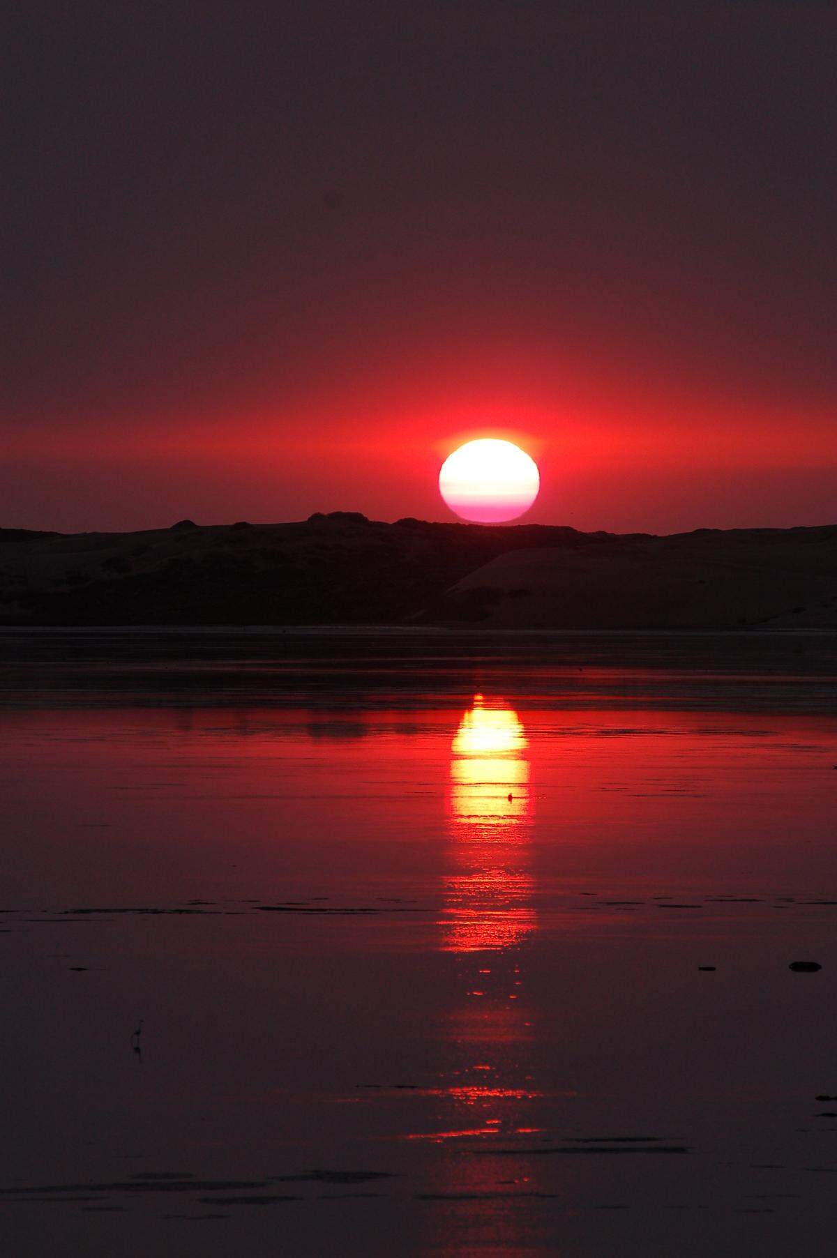 The sun is seen setting in Morro Bay.