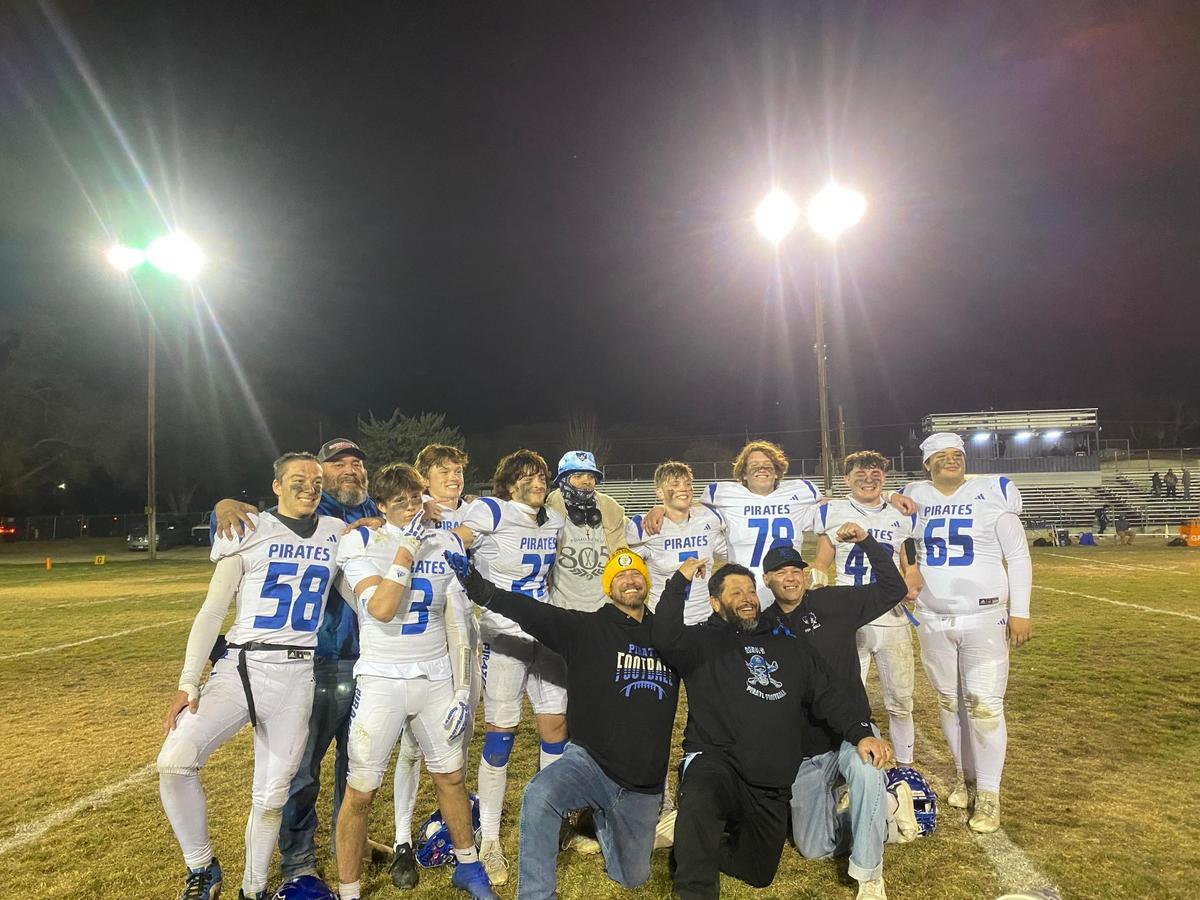 Morro Bay seniors with their fathers pose for a picture after their 28-20 win against Bishop Union on Nov. 22, 2024.