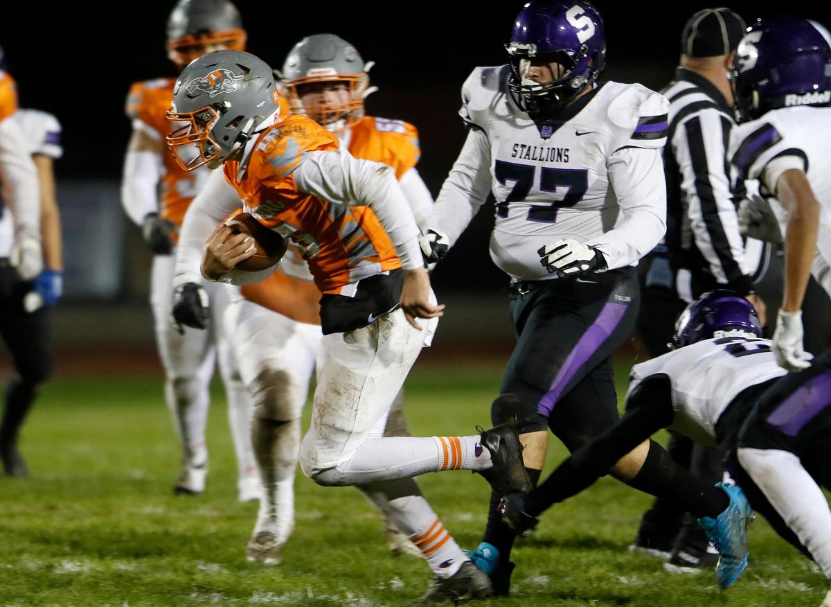 Greyhound Kane Cooks (15) carries the ball while evading Stallion linemen. Atascadero beat Madera South 39-8 in the second round of the CIF Central Section Division 5 football playoffs on Nov. 10, 2022.