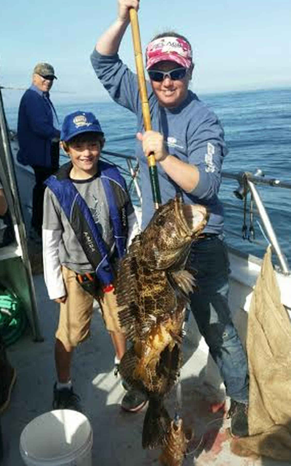 A Patriot Sportfishing captain shows off a lingcod caught by a young angler in Morro Bay.