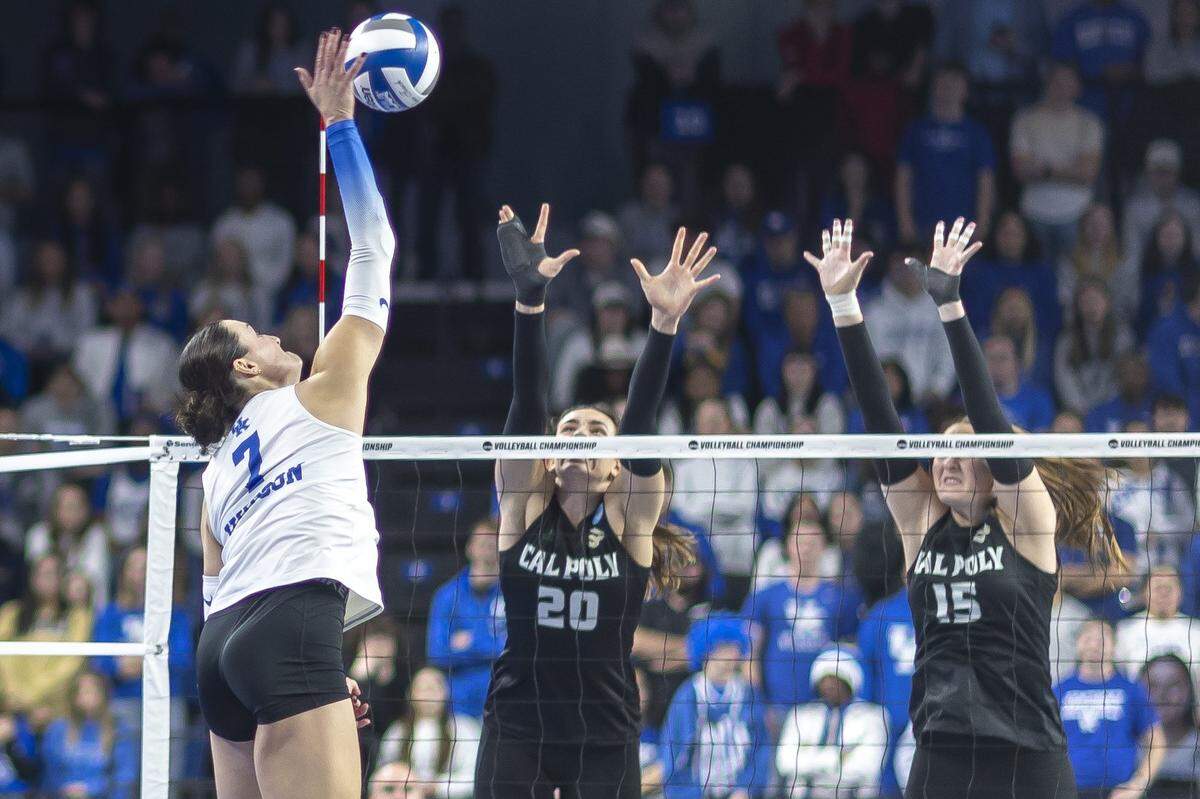 Kentucky Wildcats outside hitter Eva Hudson (7) hits the ball as Cal Poly Mustangs outside hitter Annabelle Thalken (20) and Cal Poly Mustangs middle blocker Charlotte Kelly (15) defend during the 2025 NCAA Volleyball Tournament Sweet 16 Lexington Regional at Historic Memorial Coliseum in Lexington, Ky., on Thursday, Dec. 11, 2025. Cal Poly’s season ended in a 3-0 sweep.