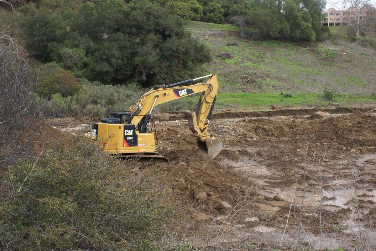 Equipment digs debris out of the San Antonio debris basin on Jan. 11, 2023.