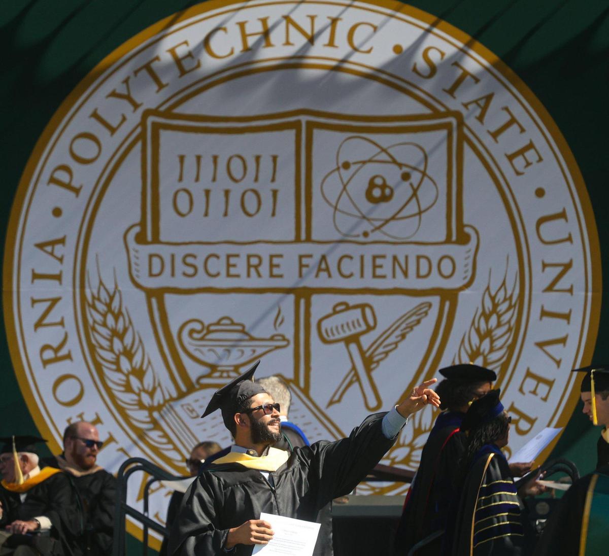 Masters degree recipient Manuel Torrez Jr. waves to Cal Poly audience. The university began a series of graduations with the College of Agriculture, Food and Environmental Sciences at Spanos Stadium on June 11, 2022.