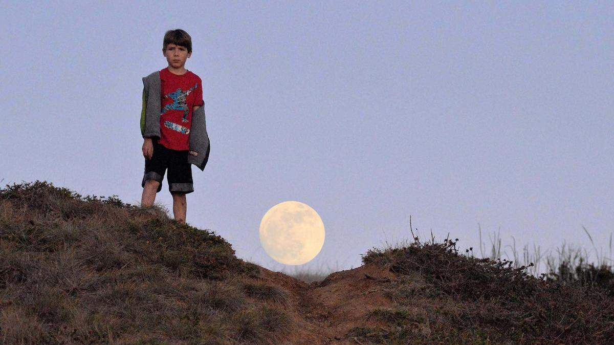 Sean Lindsey poses in front of a supermoon moon along the Central Coast.