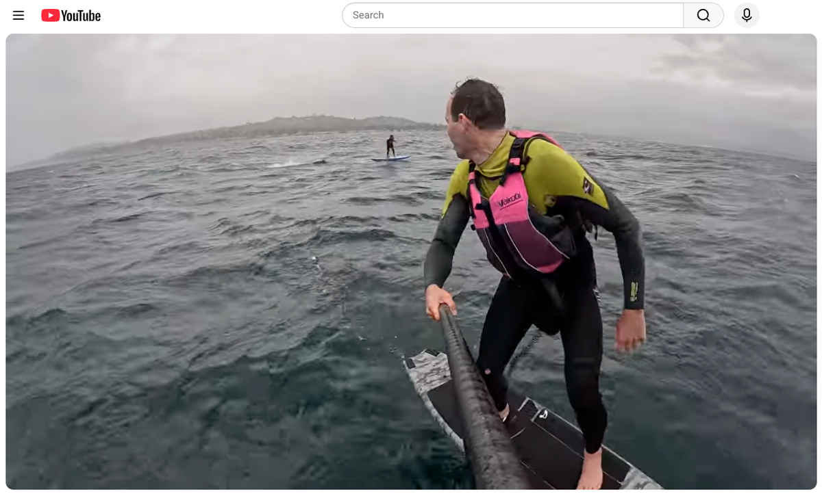 A foilboarder named Travis watches as a shark tails his friend, Ron Takeda, in the ocean along the coast between Santa Barbara and Carpinteria on April 26, 2026.