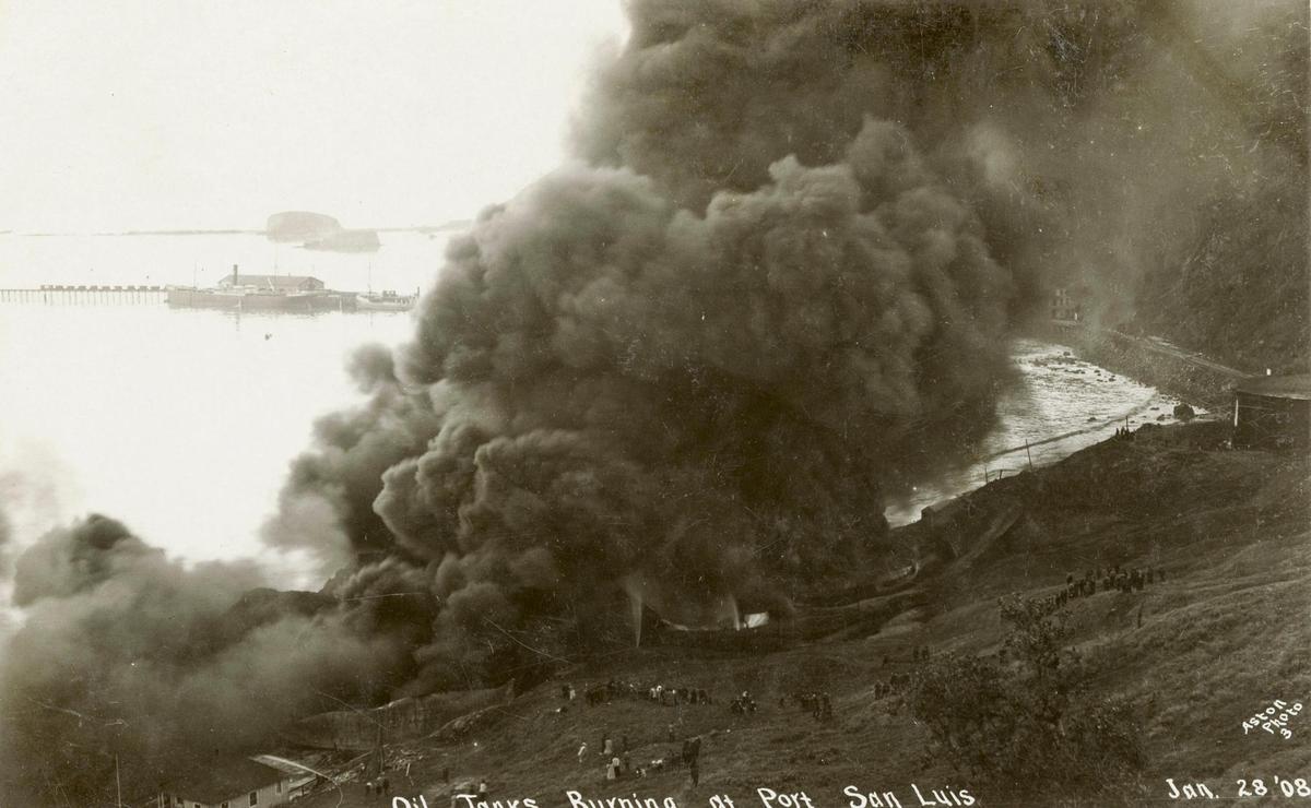 Dozens of spectators turned out to observe efforts to contain fire at the Union Oil tank farm in Port San Luis, east of today’s Diablo Canyon power plant entrance. In the background, a tanker is moored at the Harford pier. The lightning caused fire destroyed three tanks in January 1908, two years after the facility was built.