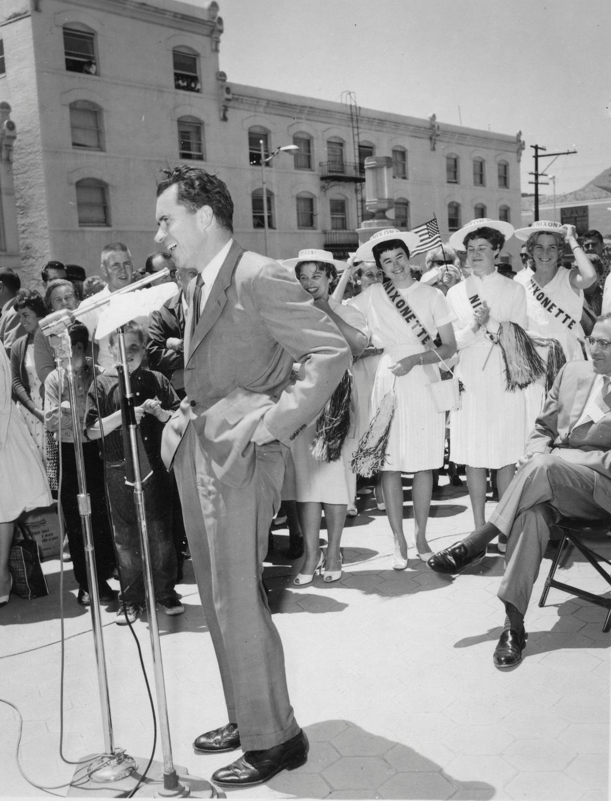 Richard M. Nixon speaks on the steps of the San Luis Obispo County courthouse on May 31, 1962, while campaigning for governor of California. The man seated with his legs crossed at right is Peter Andre. In the background are the Cal Poly Nixonettes. Following his address, the public was invited to meet him in the Fremont Theater lobby.
