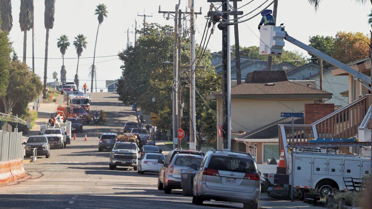 A utility crew works on downed lines on Bello Street in Pismo Beach next to Highway 101, on Dec. 18, 2025. Northbound traffic on 101 was at a standstill back to 4th street.