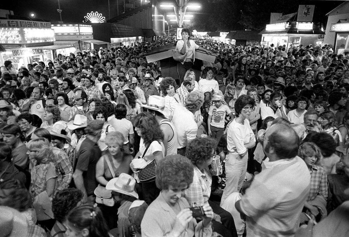 One woman seeks higher ground in crush of fairgoers on the California Mid-State Fair midway on Aug. 7, 1982, between shows by super-attraction Kenny Rogers. Then, entry and exit were through the same gates; now the Paso Robles fair has changed the entry and exit flow since then.