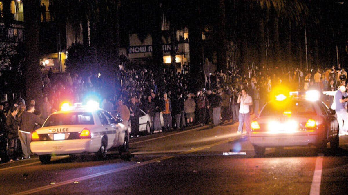 San Luis Obispo police officers attempt to disperse thousands of Mardi Gras partiers on California Street east of Foothill Boulevard on Feb. 22, 2004.