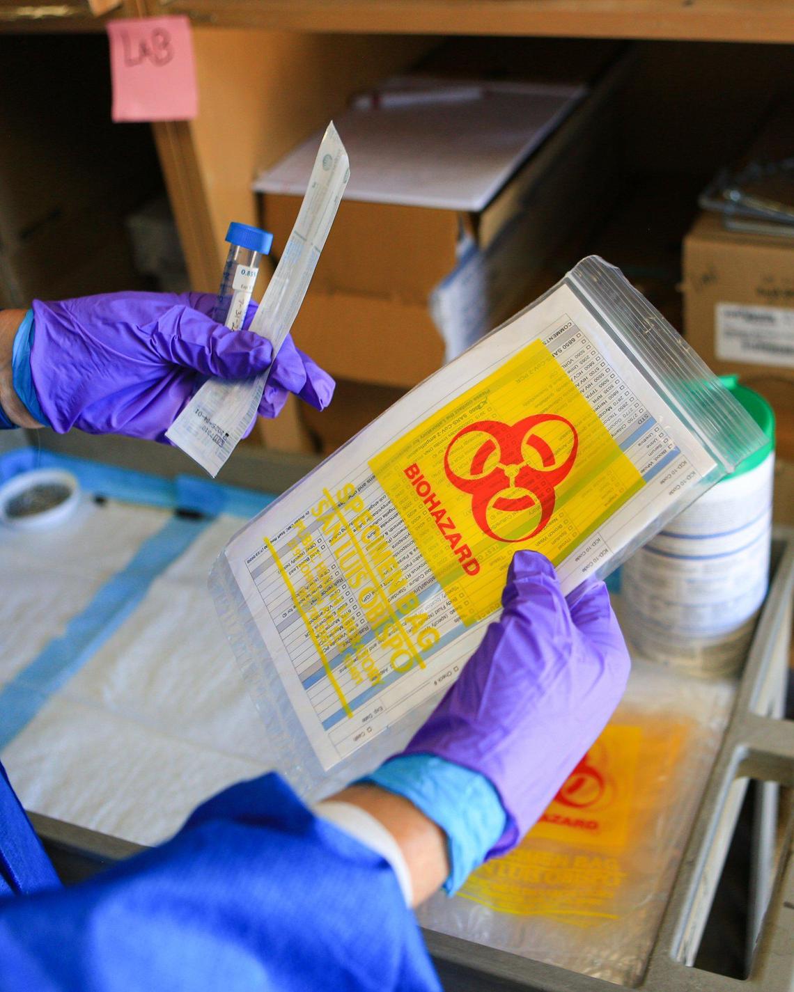 A team of three workers keeps coronavirus testing materials organized so that they can maintain the pace of a test scheduled every 10 minutes at the San Luis Obispo County Public Health Department.