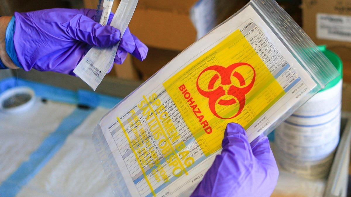 A team of three workers keeps coronavirus testing materials organized so that they can maintain the pace of a test scheduled every 10 minutes at the San Luis Obispo County Public Health Department.