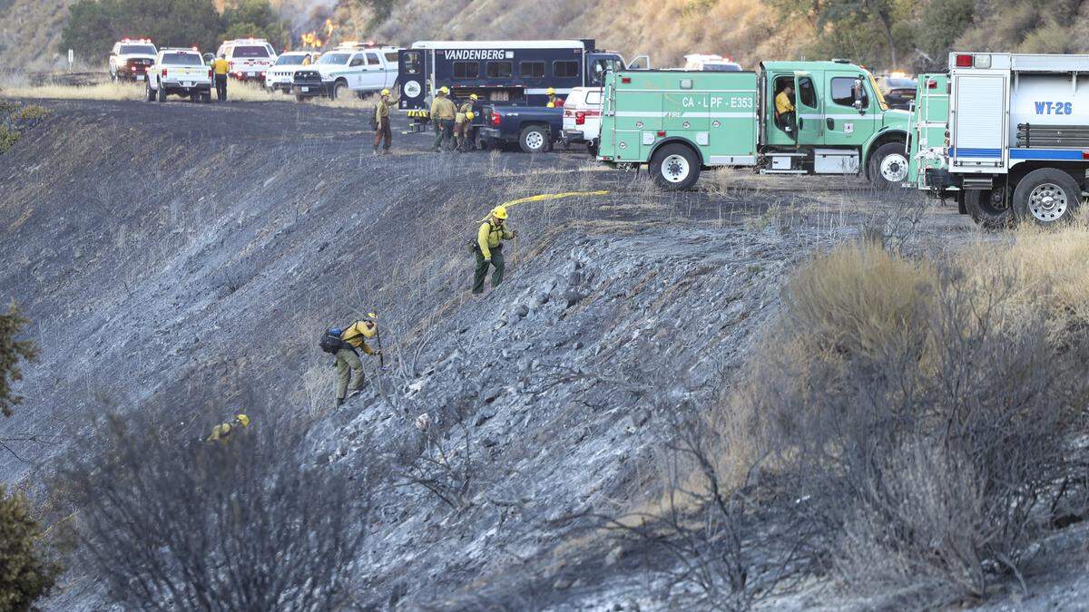 Forest Service firefighters return to the highway ater working on hot spots in the Cuyama River. The Gifford Fire burned an estimated 5,000 acres on both sides of Highway 166 east of Highway 101 on August 1, 2025.