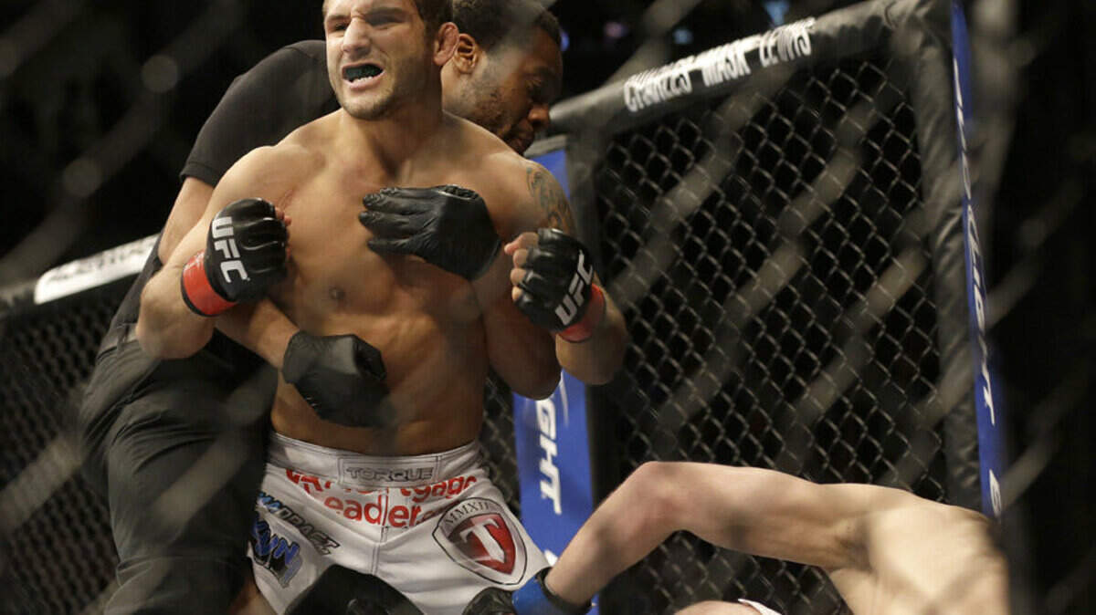 Chad Mendes, left, is held back by referee Herb Dean after beating Darren Elkins during the first round of a UFC featherweight bout April 20 in San Jose. Mendes won by technical knock out in the first round.