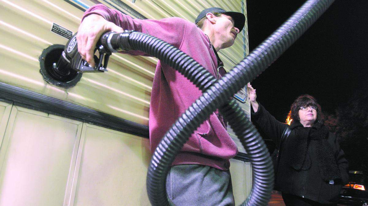 Mike Roberts puts $15 worth of gas in his 30 foot motor home with the help of Roslyn Scheuerman, homeless outreach coordinator with the Safe Parking Program in Santa Barbara.