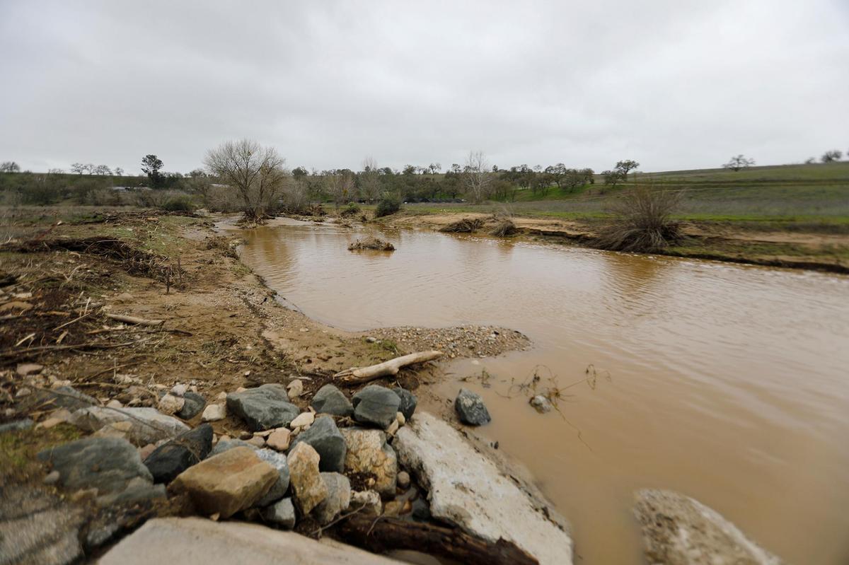 A swollen San Marcos Creek Road flows on Jan. 11, 2023, near the spot where 5-year-old Kyle Doan was swept away in San Miguel on Monday.