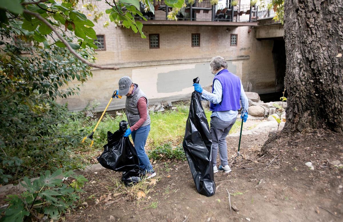 Dede Janzen, right, and Dorothy McLean, both of San Luis Obispo, team up to clean areas around San Luis Creek downtown on Sept. 17, 2022.