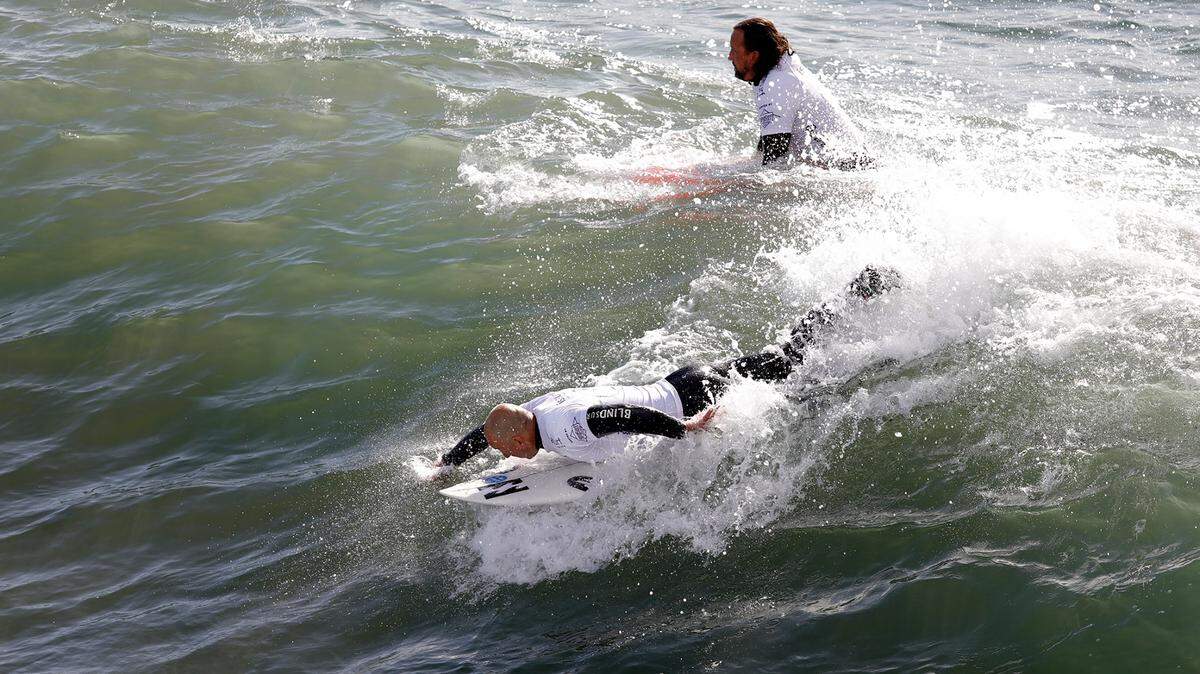 In a qualifying vision impaired (VI) round, Matt Formston, from Australia, assisted by his guide, competes in the first heat, Tuesday, Dec. 6. The 2022 Pismo Beach ISA World Para Surfing Championships is hosted by AmpSurf.